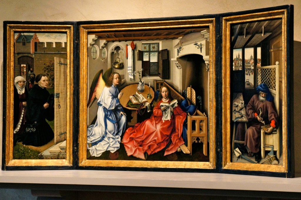 E uma das pièces de résistence, o tríptico da anunciação por Robert Campin (Belga) de circa 1427. Este quadro está em um estado impecável por ter sido sempre muito bem cuidado. Ele contém dezenas de simbolismos que nem sempre são necessariamente precisos para a época. Reparem (aumentando a imagem) no jesus na cruz que chega no raio de sol!