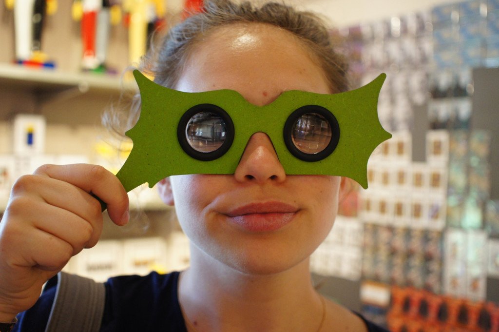 Allegra na lojinha com uma parodia dos óculos irônicos de Peggy Guggenheim