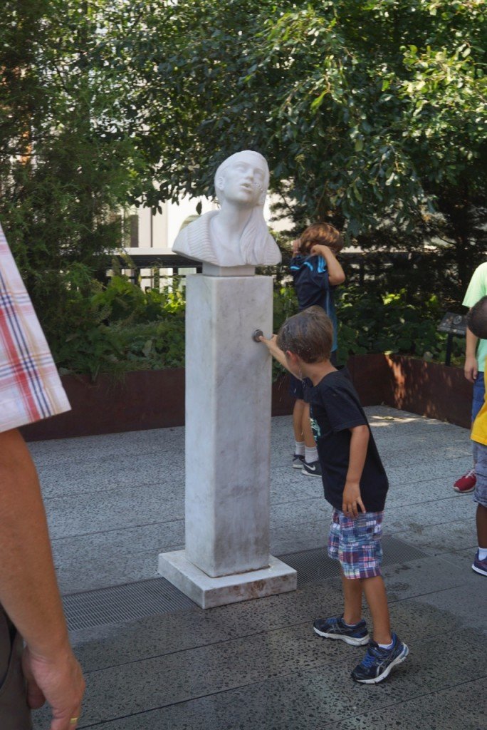 Este bebedouro é novo. Quando as pessoas bebem, parecem estar dando um beijo na mulher da escultura...